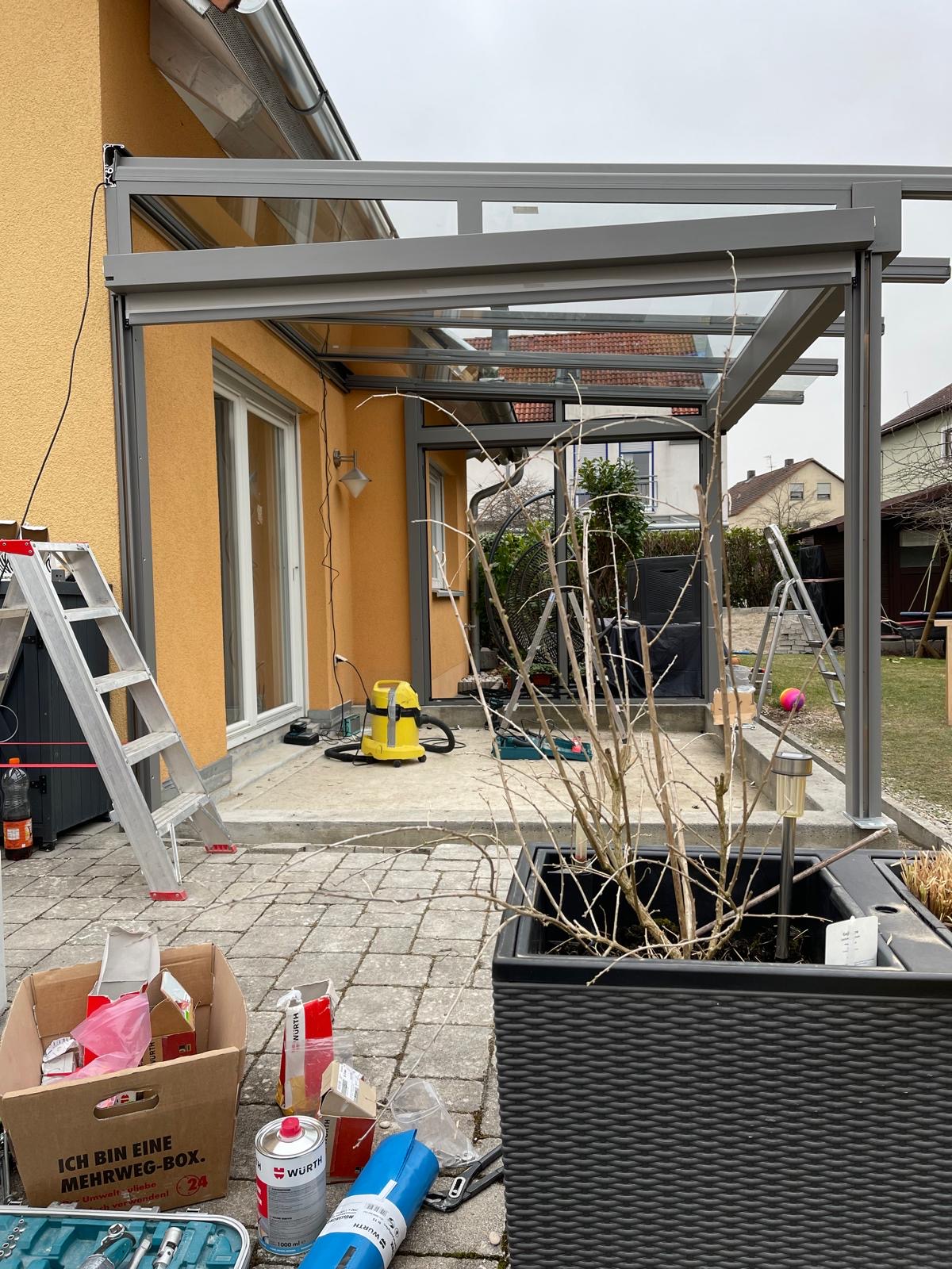 Fertig montierte Glas-Aluminium-Terrassenüberdachung an einem Einfamilienhaus